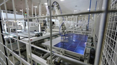 A robot places solar cells on a glass panel at a ReNew manufacturing plant on the outskirts of Jaipur, India, Thursday, Aug. 21, 2025.