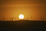 The sun rises over power-generating wind turbines at the Capital Wind Farm near Canberra, Australia, on March 18, 2025.