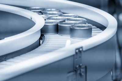 Tin cans moving on curved conveyor belt.