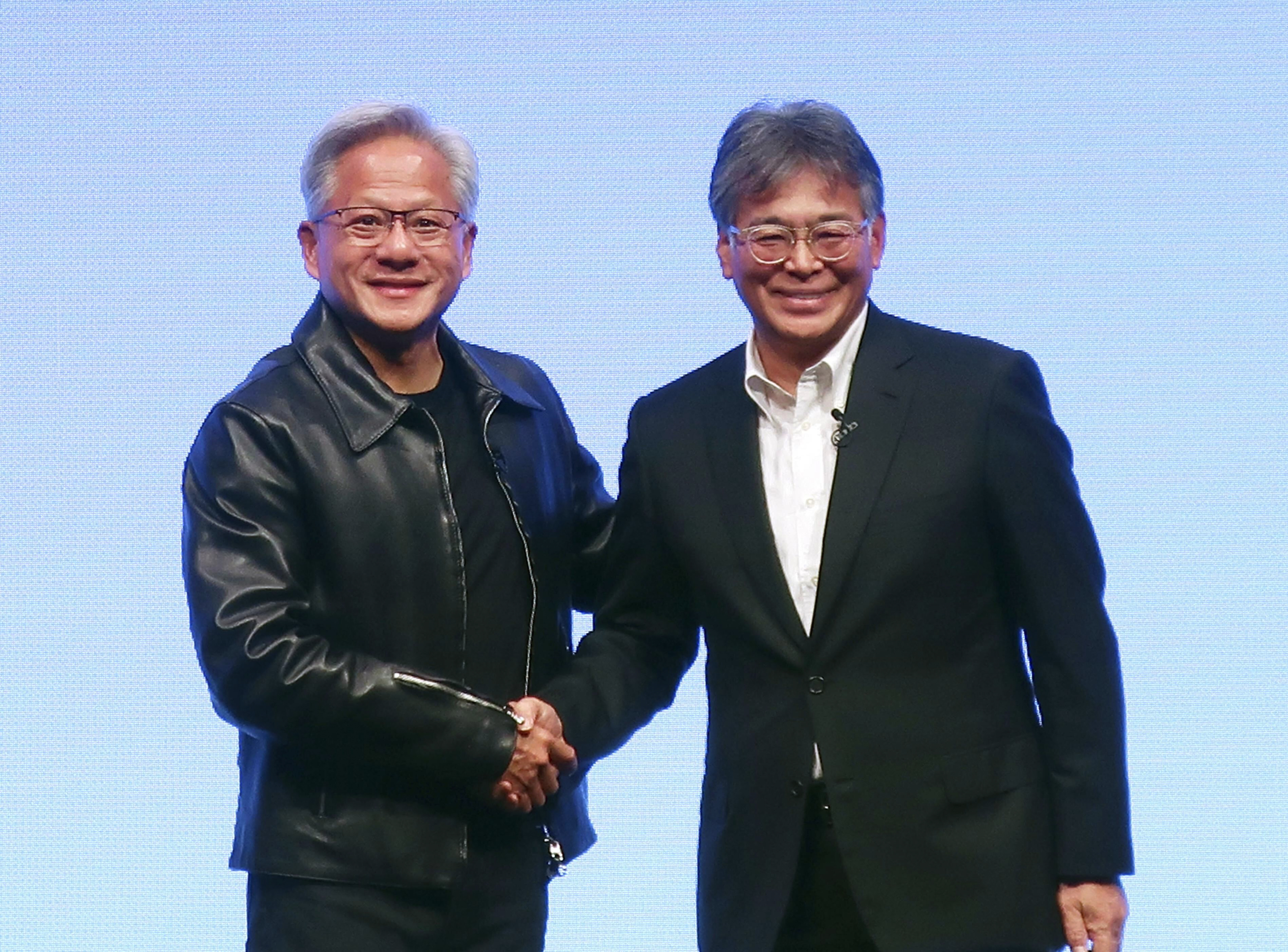 Nvidia Chief Executive Jensen Huang, left, and Fujitsu Chief Executive Takahito Tokita shake hands during an announcement in Tokyo Friday, Oct. 3, 2025.