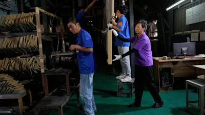 Workers check aluminum panels produced at a factory of Kam Pin Industrial (HK) Ltd, in Dongguan city in southern China's Guangdong province April 17, 2025.
