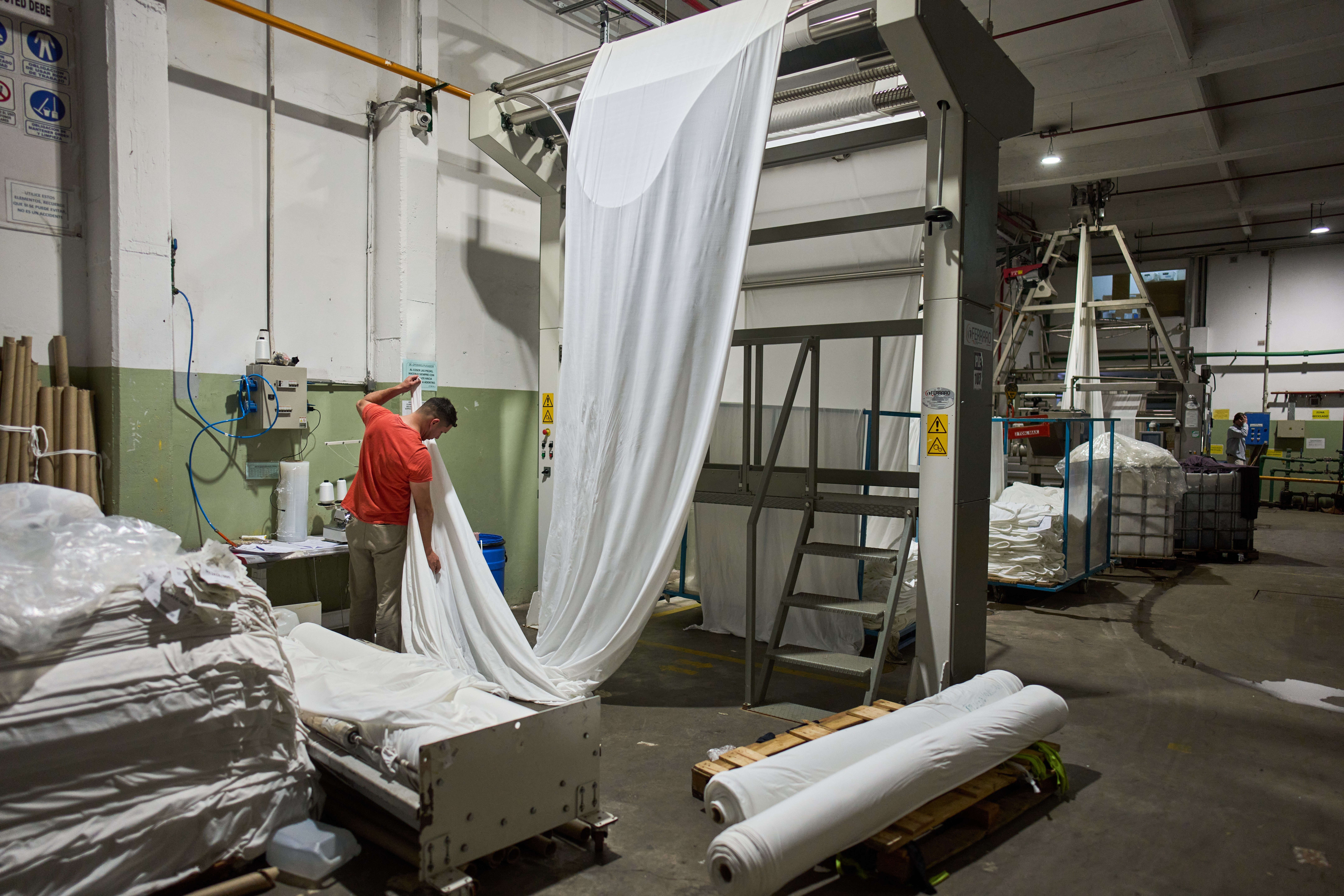 German Flores measures fabric at the Galfione Group textile factory in Buenos Aires, Argentina, Monday, Oct. 13, 2025.