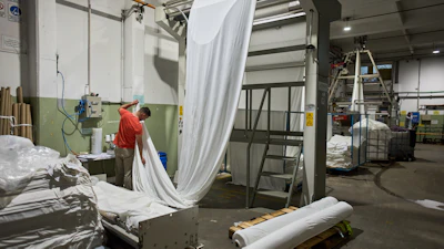 German Flores measures fabric at the Galfione Group textile factory in Buenos Aires, Argentina, Monday, Oct. 13, 2025.