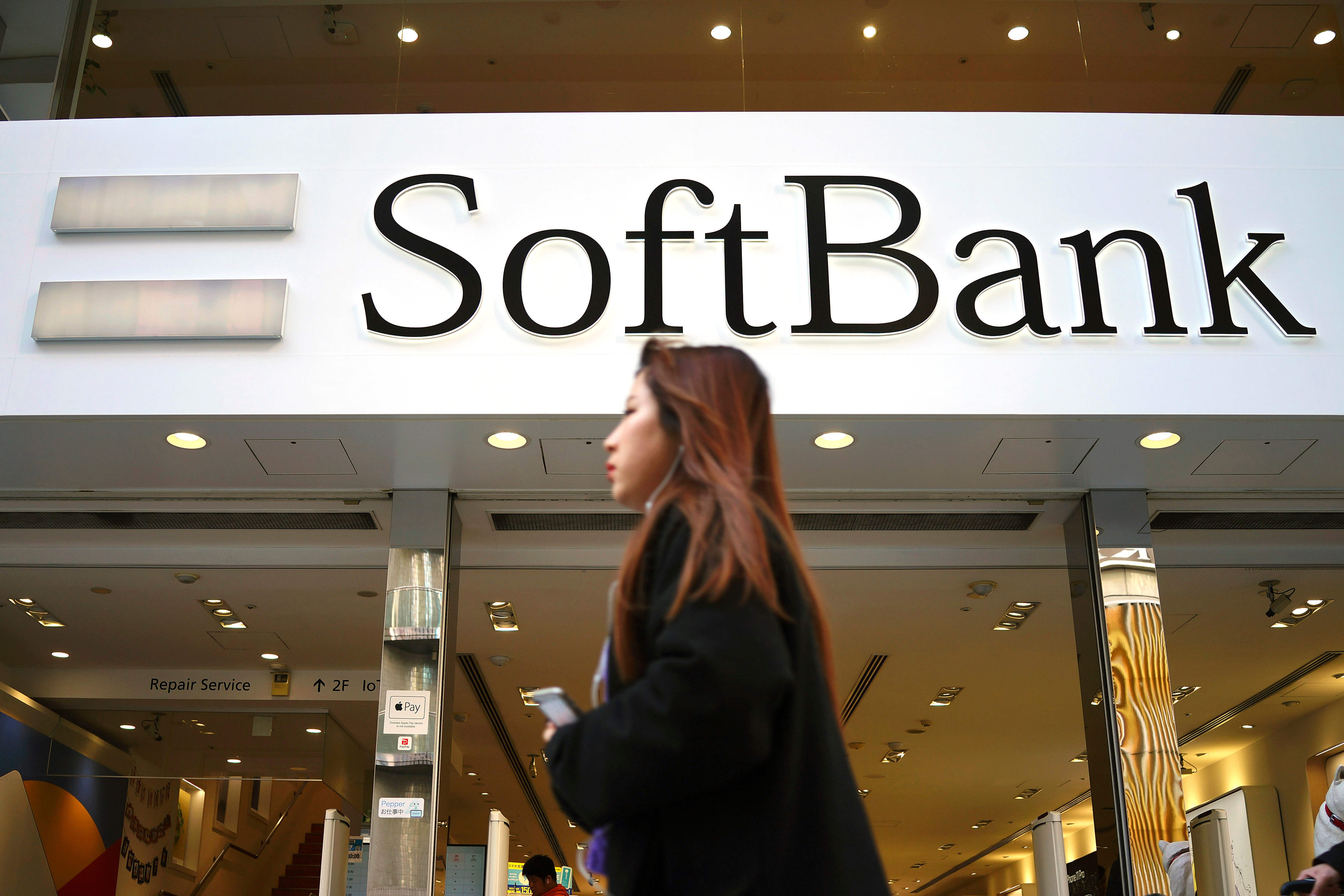 A woman walks in front of SoftBank store in Ginza shopping district in Tokyo, Jan. 20, 2020.