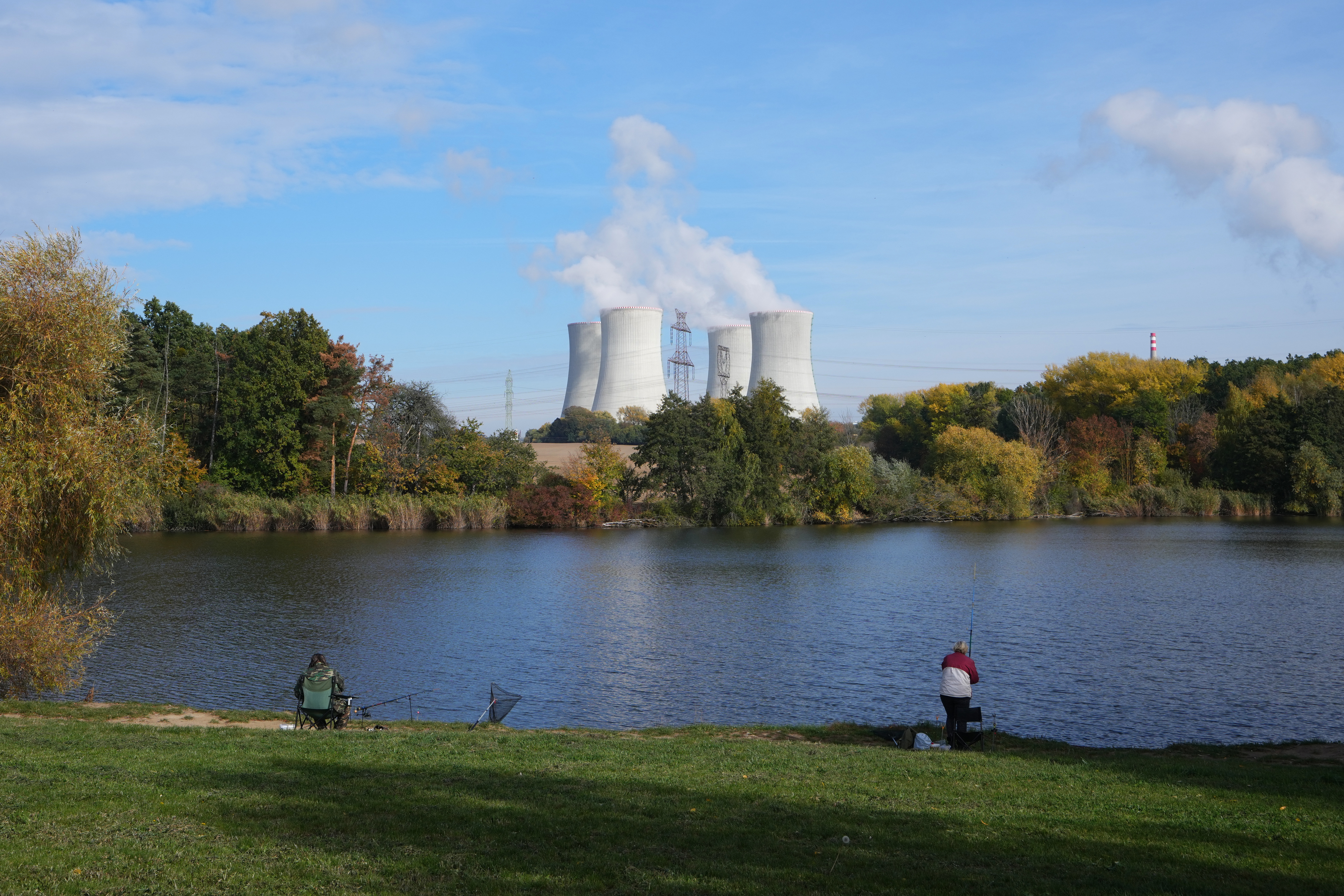 People fish near the towering Dukovany nuclear power plant, background, in Dukovany, Czech Republic, Oct. 21, 2025.