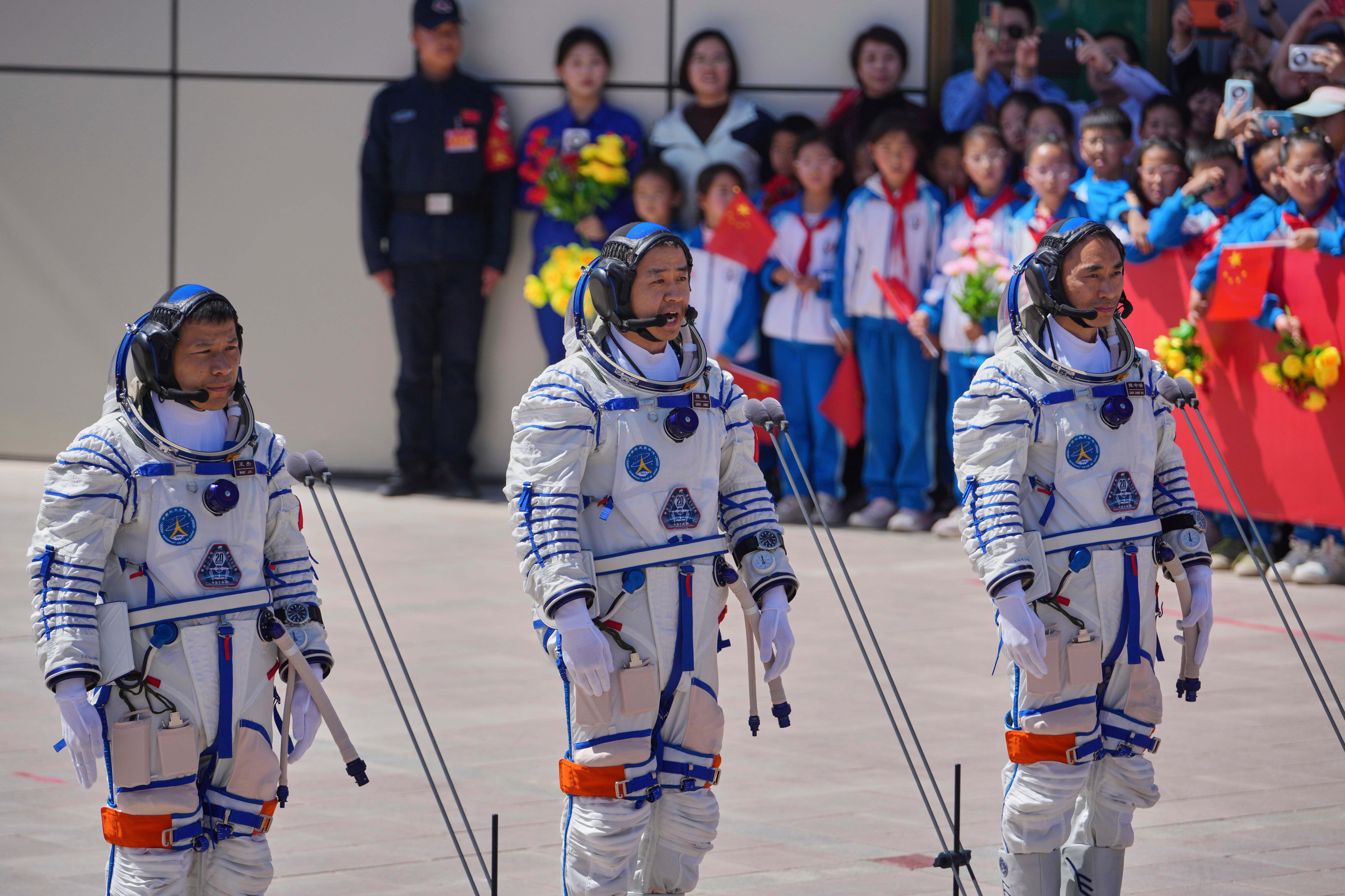 Chinese astronaut for the Shenzhou 20 mission, Chen Dong, center, speaks next to his comrades Chen Zhongrui, right, and Wang Jie as they attend a send-off ceremony for their manned space mission at the Jiuquan Satellite Launch Center in northwestern China, Thursday, April 24, 2025.