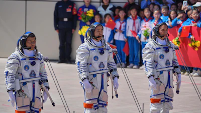 Chinese astronaut for the Shenzhou 20 mission, Chen Dong, center, speaks next to his comrades Chen Zhongrui, right, and Wang Jie as they attend a send-off ceremony for their manned space mission at the Jiuquan Satellite Launch Center in northwestern China, Thursday, April 24, 2025.
