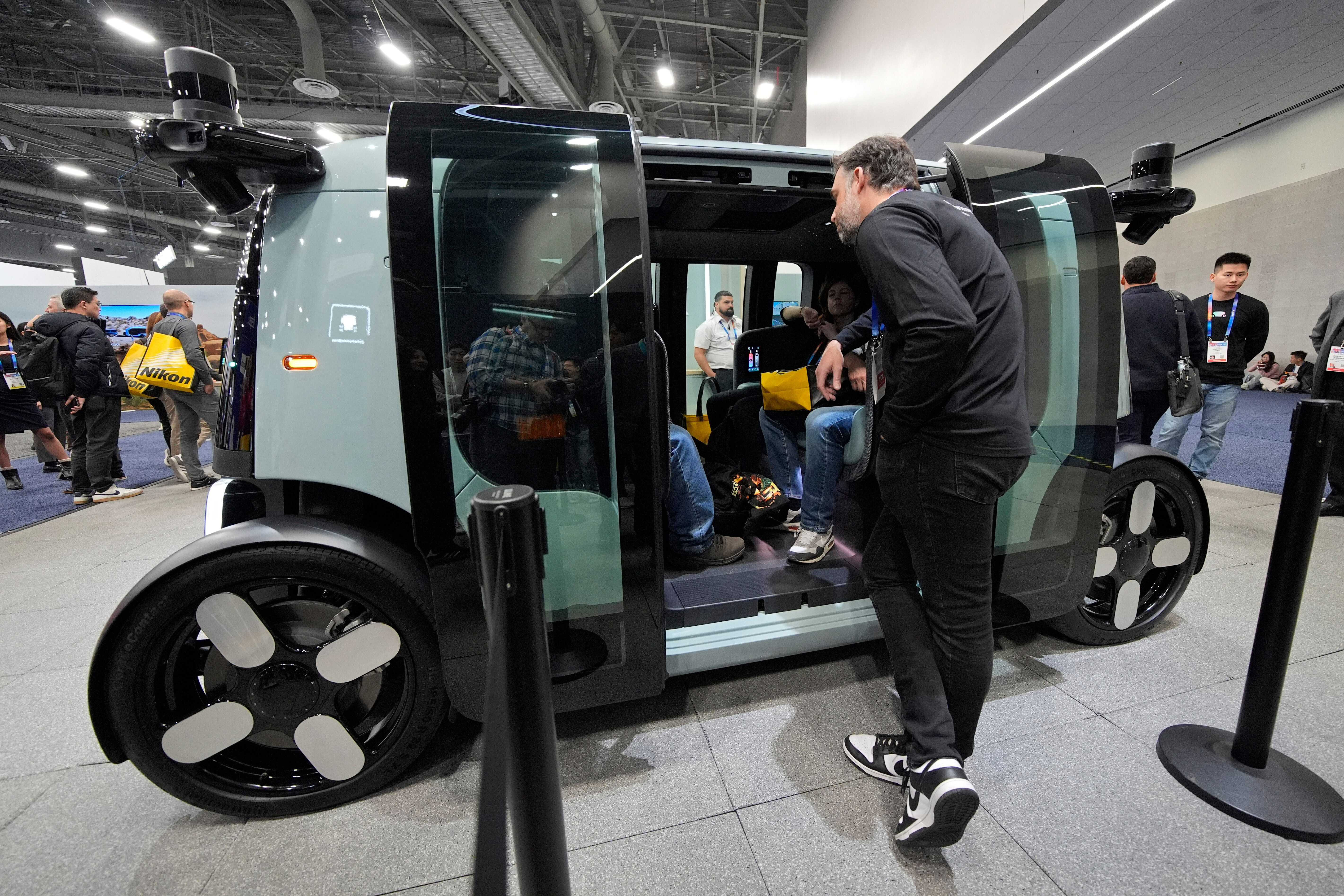 People view a Zoox self-driving vehicle at the Zoox booth during the CES tech show, Jan. 7, 2025, in Las Vegas.