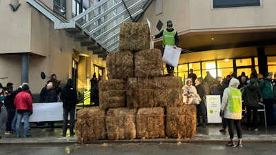 Haystacks pile up outside a court house as French oil giant TotalEnergies is on trial, accused by Belgian farmer Hugues Falys and three environmental groups of bearing responsibility for climate change, Wednesday, Nov. 19, 2025 in Tournai, Belgium.