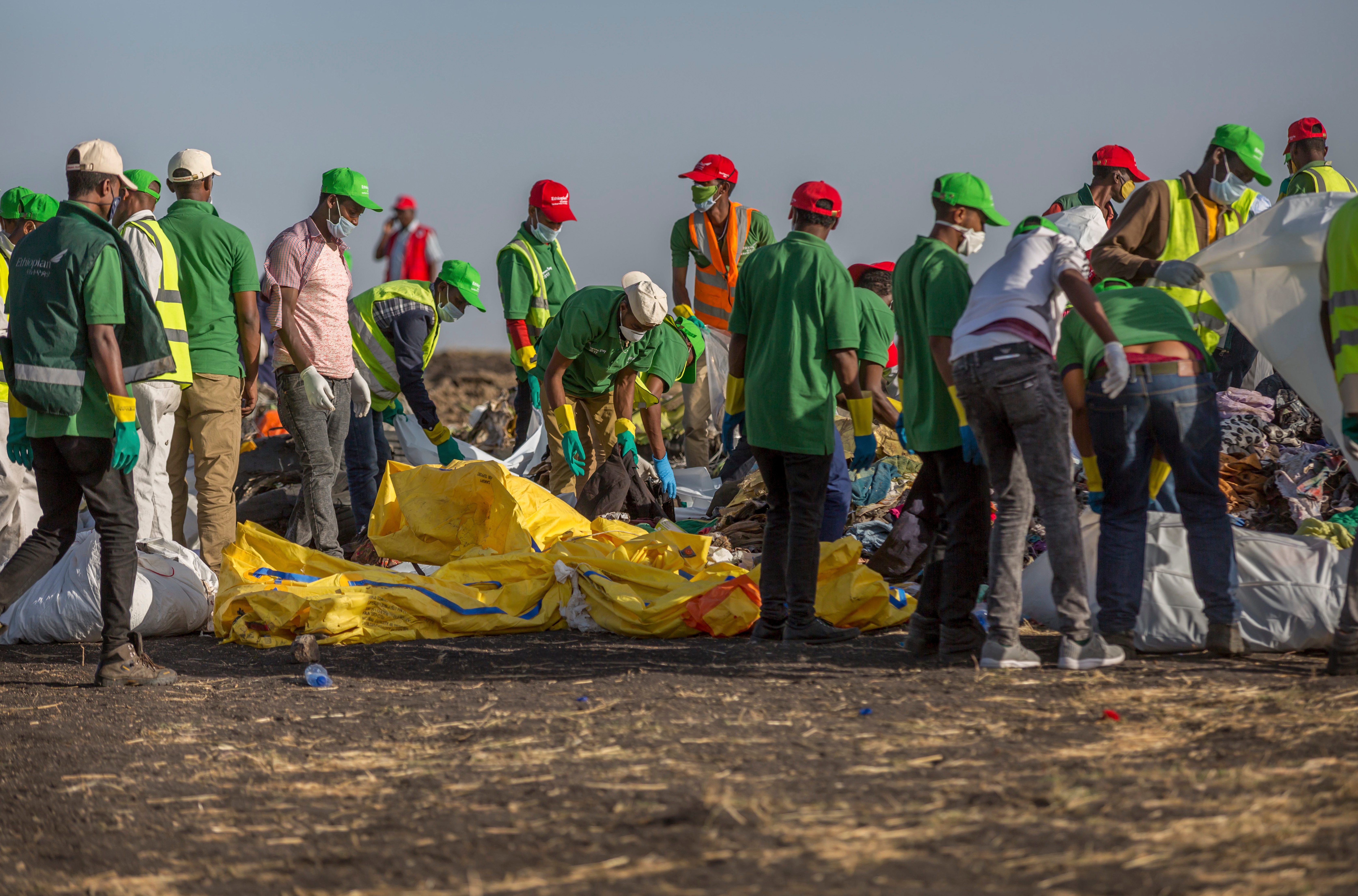 Workers collect debris on March 12, 2019 at the scene where an Ethiopian Airlines Boeing 737 Max 8 crashed shortly after takeoff, killing all 157 on board, near Bishoftu, or Debre Zeit, south of Addis Ababa, in Ethiopia.