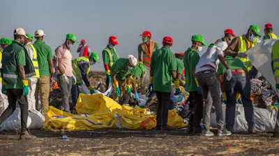 Workers collect debris on March 12, 2019 at the scene where an Ethiopian Airlines Boeing 737 Max 8 crashed shortly after takeoff, killing all 157 on board, near Bishoftu, or Debre Zeit, south of Addis Ababa, in Ethiopia.