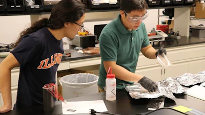 Aerospace undergrad Alex Kuehnle observes PhD student Ivan Wu in the composites laboratory at the University of Illinois Urbana-Champaign.