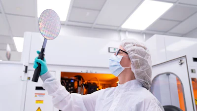 A Northrop Grumman engineer inspects a microelectronics wafer at the Central Florida manufacturing and advanced packaging facility.