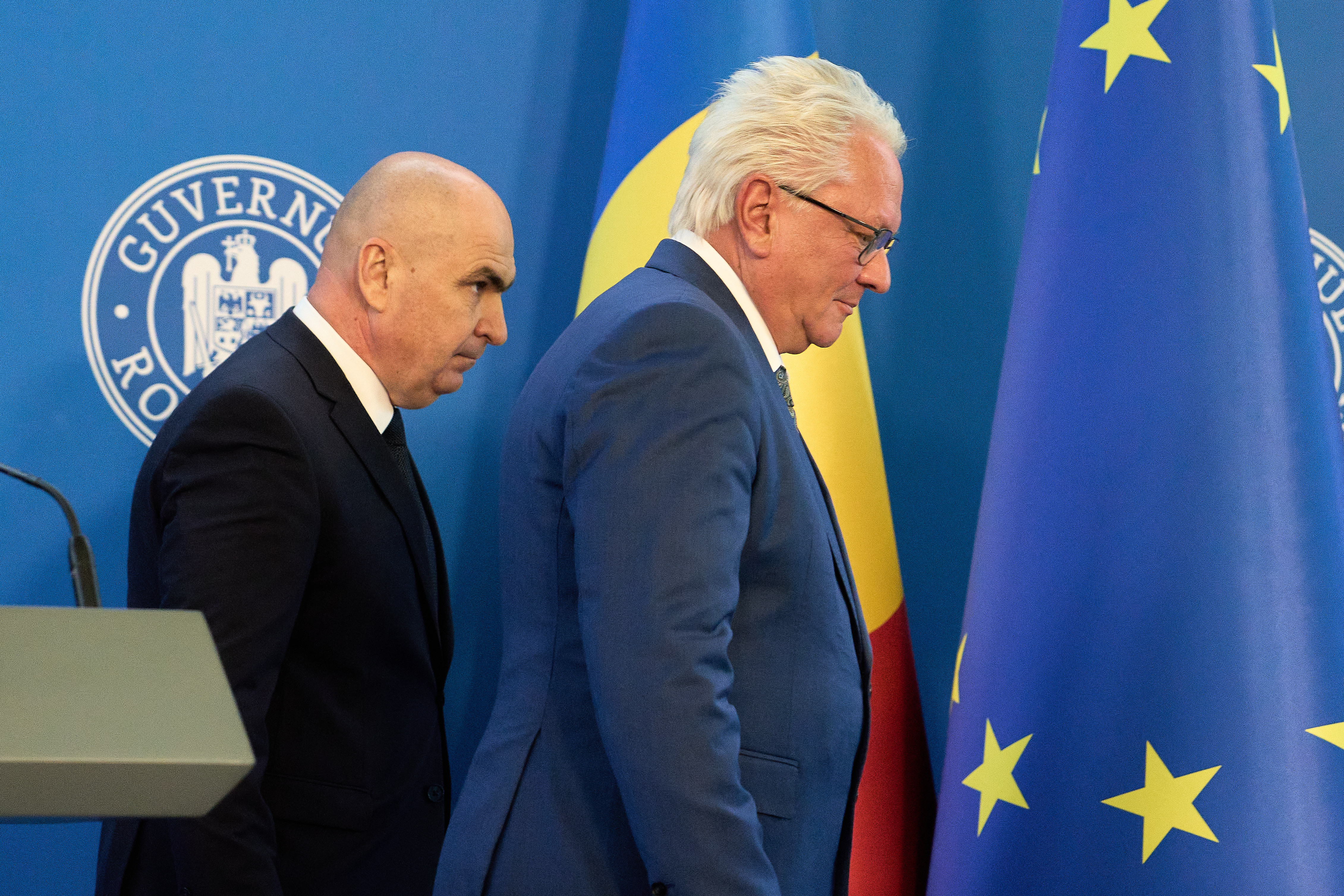 Romanian Prime Minister Ilie Bolojan, left, and Germany's Rheinmetall AG CEO Armin Papperger leave after a joint press statement in Bucharest, Romania, Monday, Nov. 3, 2025, following the signing a partnership to build an ammunition powder factory.