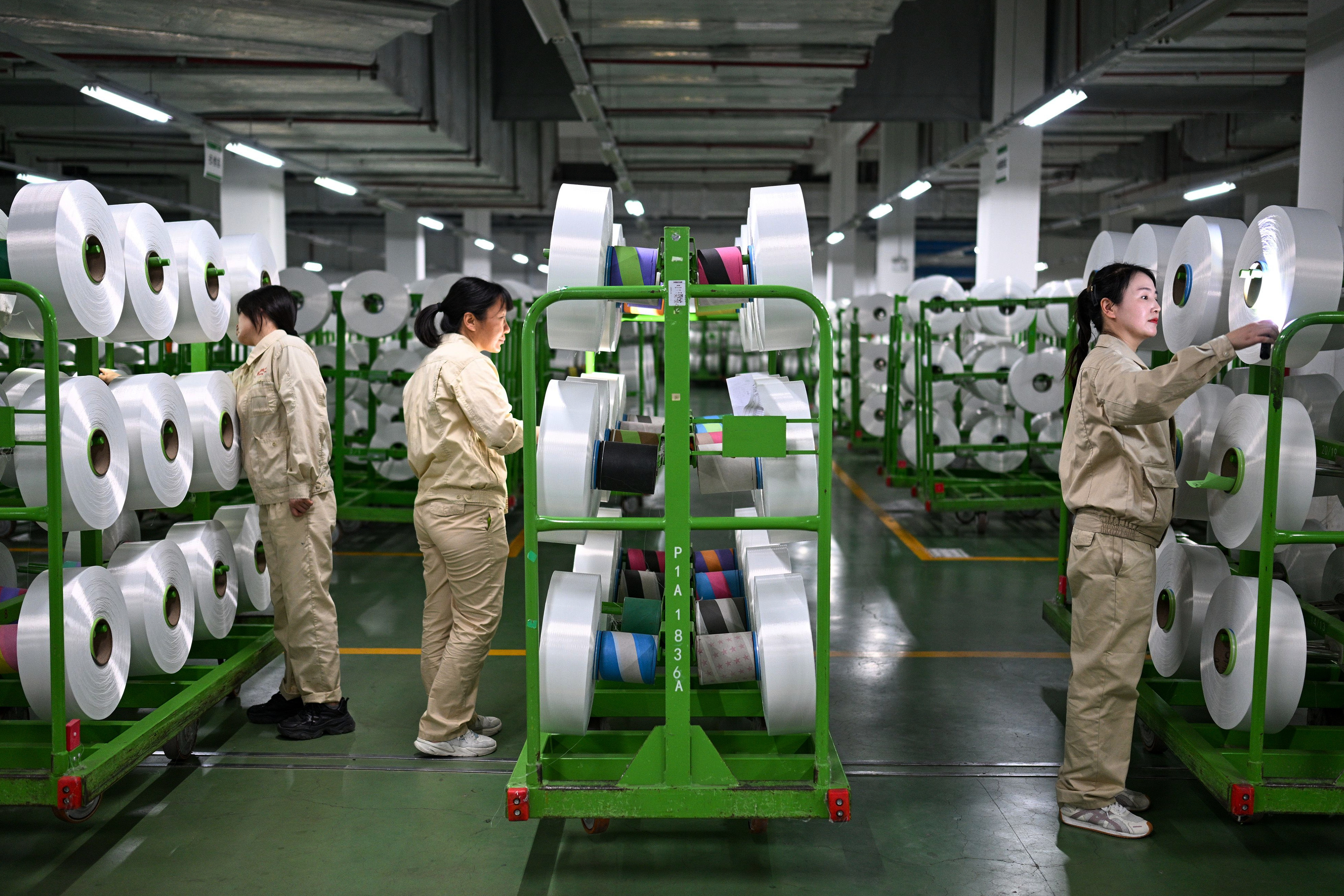 Workers check on the products in the world's largest production base for recycled polyester filament yarn, Siyang, China, Oct. 24, 2025.