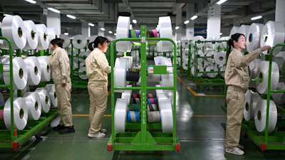 Workers check on the products in the world's largest production base for recycled polyester filament yarn, Siyang, China, Oct. 24, 2025.