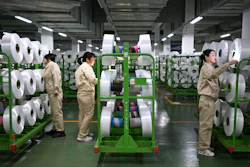 Workers check on the products in the world's largest production base for recycled polyester filament yarn, Siyang, China, Oct. 24, 2025.