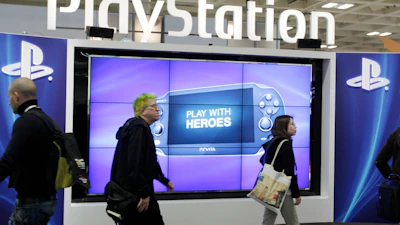 Attendees walking past the Sony PlayStation PS Vita console on display in the Sony PlayStation booth at the Game Developers Conference in San Francisco on March 8, 2012.