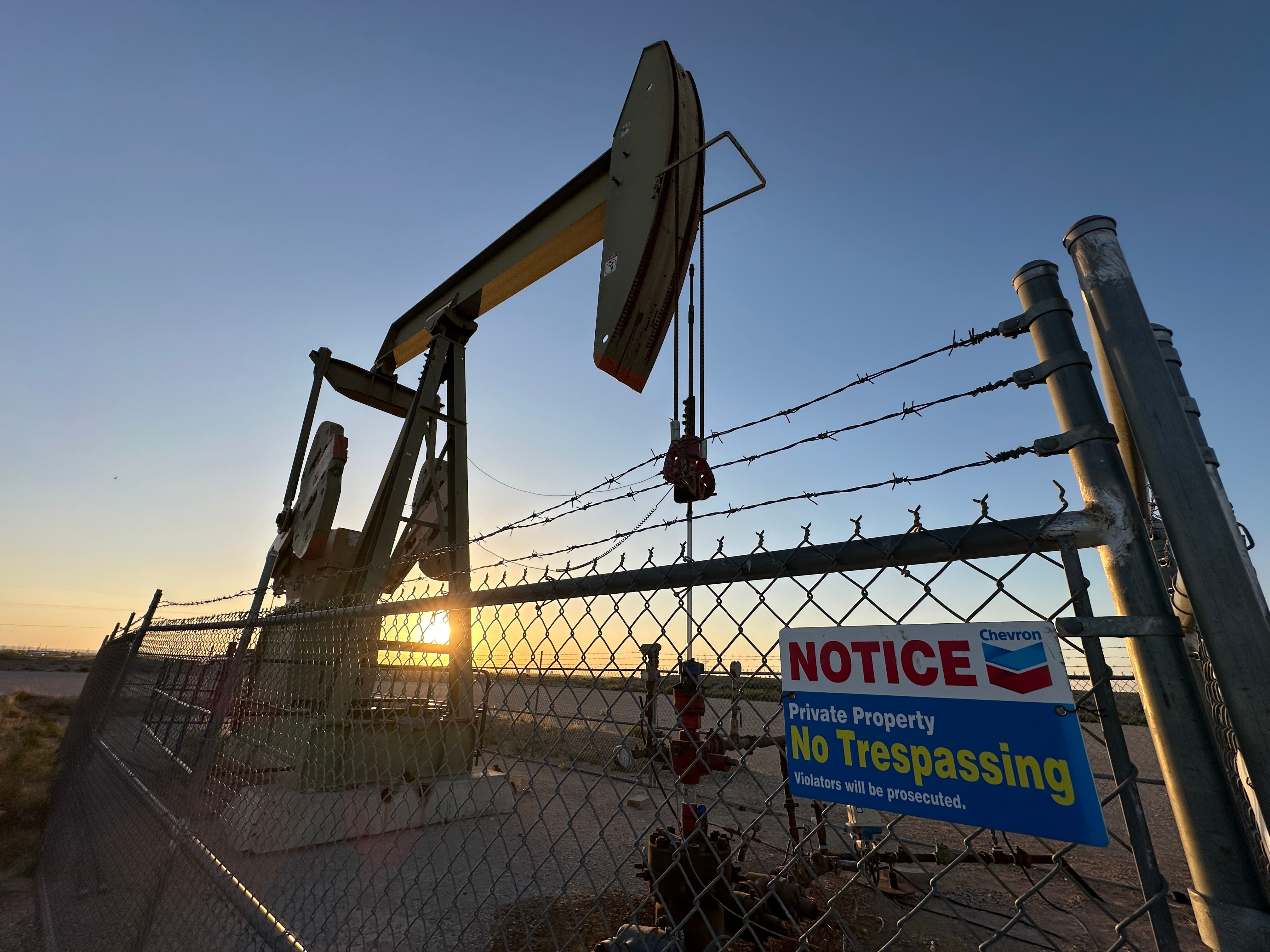The sun sets behind an oil pump jack near Loving, N.M., on Tuesday, May 20, 2025.