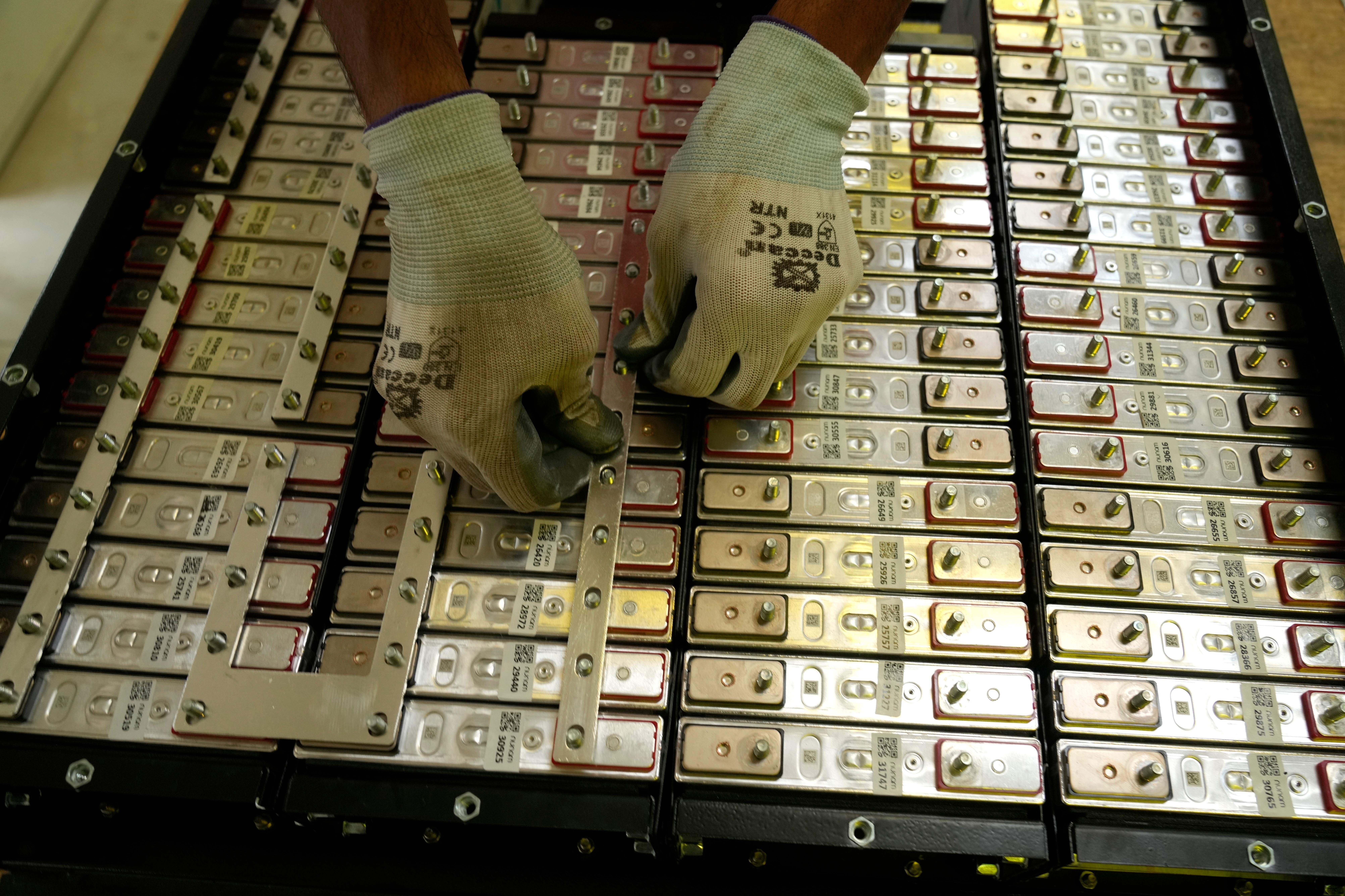 A battery production engineer at Nunam assembles a refurbished battery pack, made from used electric vehicle batteries, at their facility in Bengaluru, India, Oct. 8, 2024.