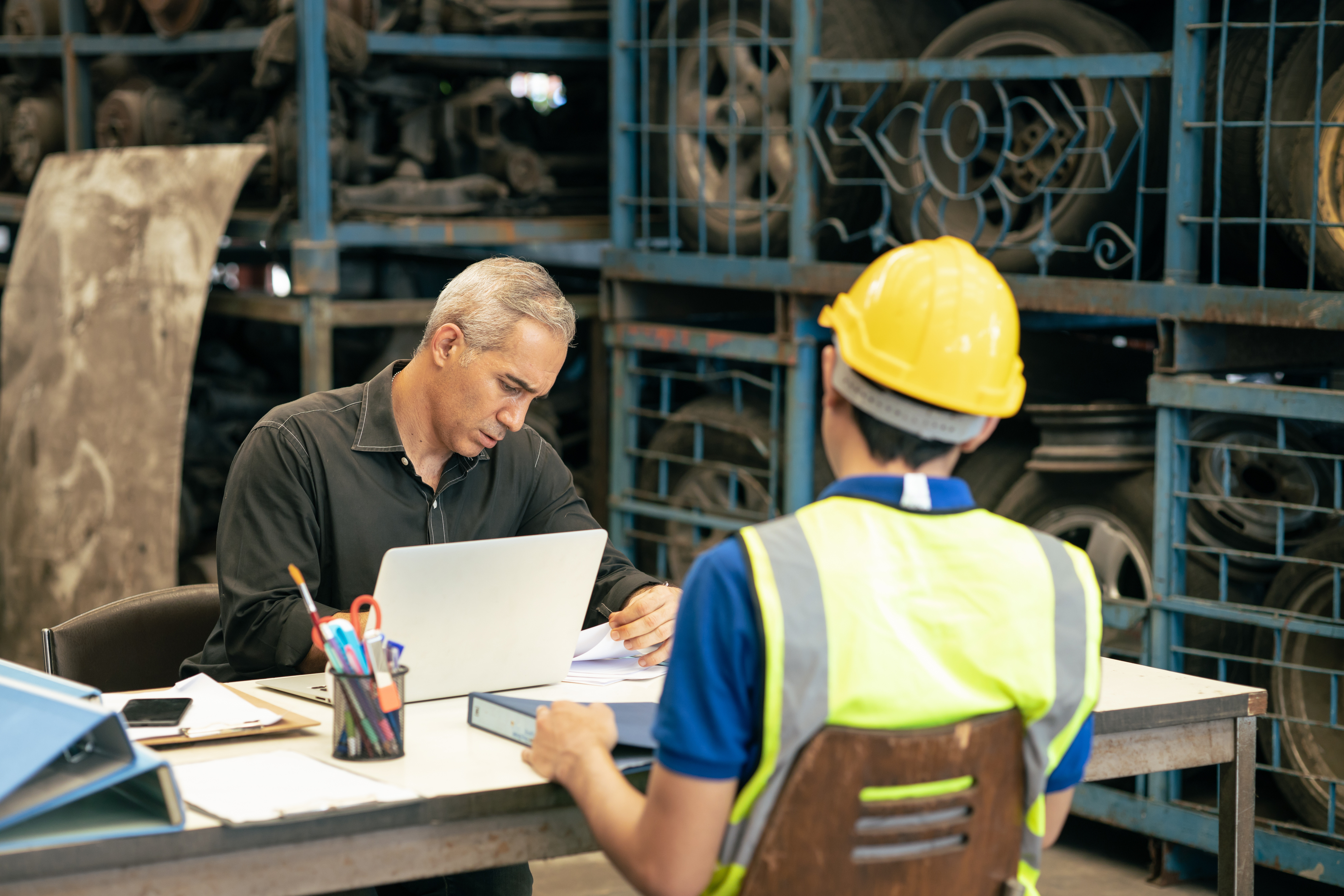 Manufacturer reviewing documents amid the recruitment process.