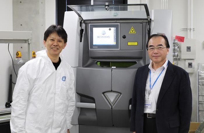 Naoki Takata of Nagoya University, lead researcher on the project (left), and Masaki Kato, senior author and division head of Aichi Center for Industry and Science Technology (right), with the center's laser 3D printer that creates stronger, heat-resistant aluminum alloys layer by layer.