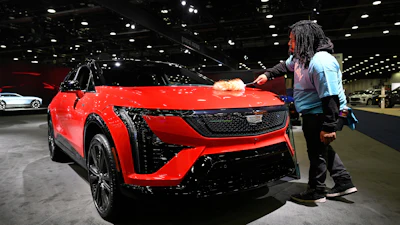 A worker dusts on a 2026 Cadillac Optiq Premium Sport vehicle at the Detroit Auto Show, Wednesday, Jan. 14, 2026, in Detroit.