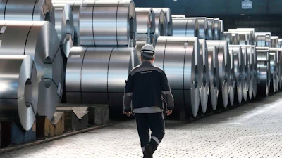 A steel worker walks beside steel coils at the Thyssenkrupp steelworks in Duisburg, Germany, March 20, 2025.