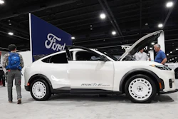 Shoppers look over a 2025 Mach-E electric utility vehicle in the Ford display at the Colorado Auto Show, April 17, 2025, in Denver.