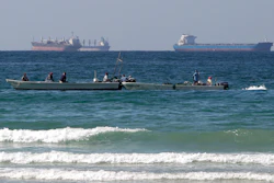 Fishermen work in front of oil tankers south of the Strait of Hormuz Jan. 19, 2012, offshore the town of Ras Al Khaimah in United Arab Emirates.