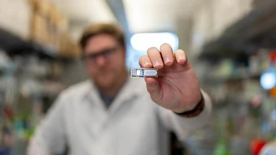 Rice University Ph.D. student Chris Wright holds the implant, which uses cells to manufacture pharmaceutical drugs beneath the skin.