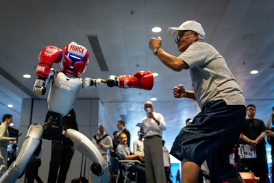 A humanoid robot squares off against a visitor during a demonstration at an exhibition in Hong Kong on Monday, April 13, 2026.