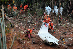 In this photo released by Xinhua News Agency, search and rescue workers search through debris at the China Eastern flight crash site in Tengxian County in southern China's Guangxi Zhuang Autonomous Region on March 24, 2022.