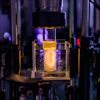 Holographic projection of a human ear model on a sample vial.