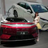 Models stand next to a latest EV car from Chinese automaker BYD showcased at the Auto China 2026, in Beijing, April 25, 2026.