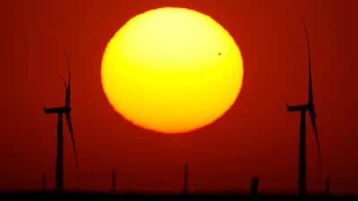 Wind turbines are silhouetted against the sky at sunset May 15, 2026, near Cimarron, Kan.