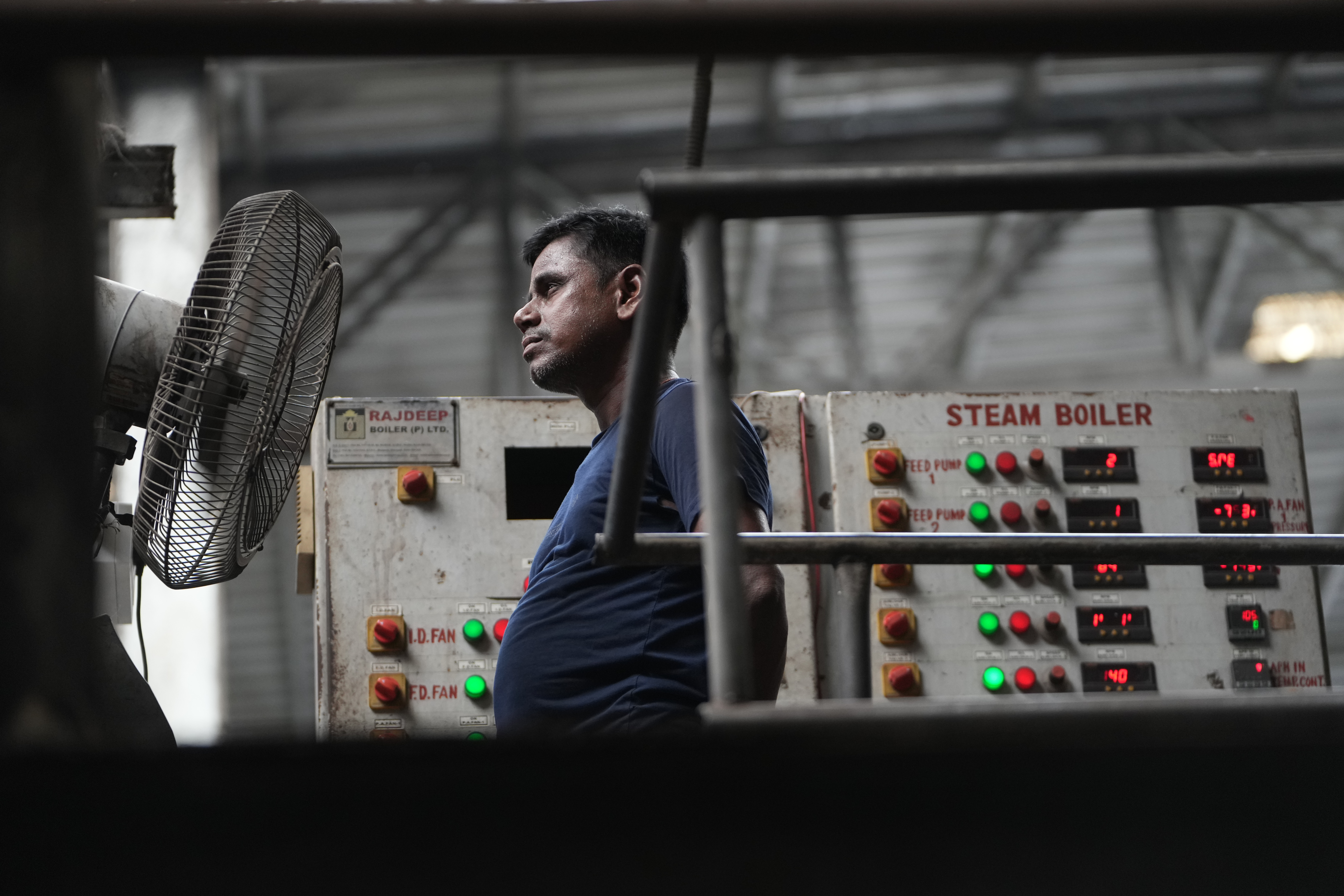 A worker stands in front of a fan on a hot day at Vinit Fabrics in Palsana near Surat, India, Tuesday, May 26, 2026.