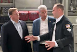 Energy Secretary Chris Wright, center, and Under Secretary of Defense Michael Duffey, left, listen as Isaiah Taylor, CEO of Valar Atomics, discusses a microreactor developed by Valar to generate nuclear power for the military and commercial customers, Feb. 15, 2026, in-flight, on board a C-17.