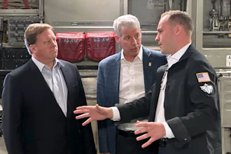 Energy Secretary Chris Wright, center, and Under Secretary of Defense Michael Duffey, left, listen as Isaiah Taylor, CEO of Valar Atomics, discusses a microreactor developed by Valar to generate nuclear power for the military and commercial customers, Feb. 15, 2026, in-flight, on board a C-17.