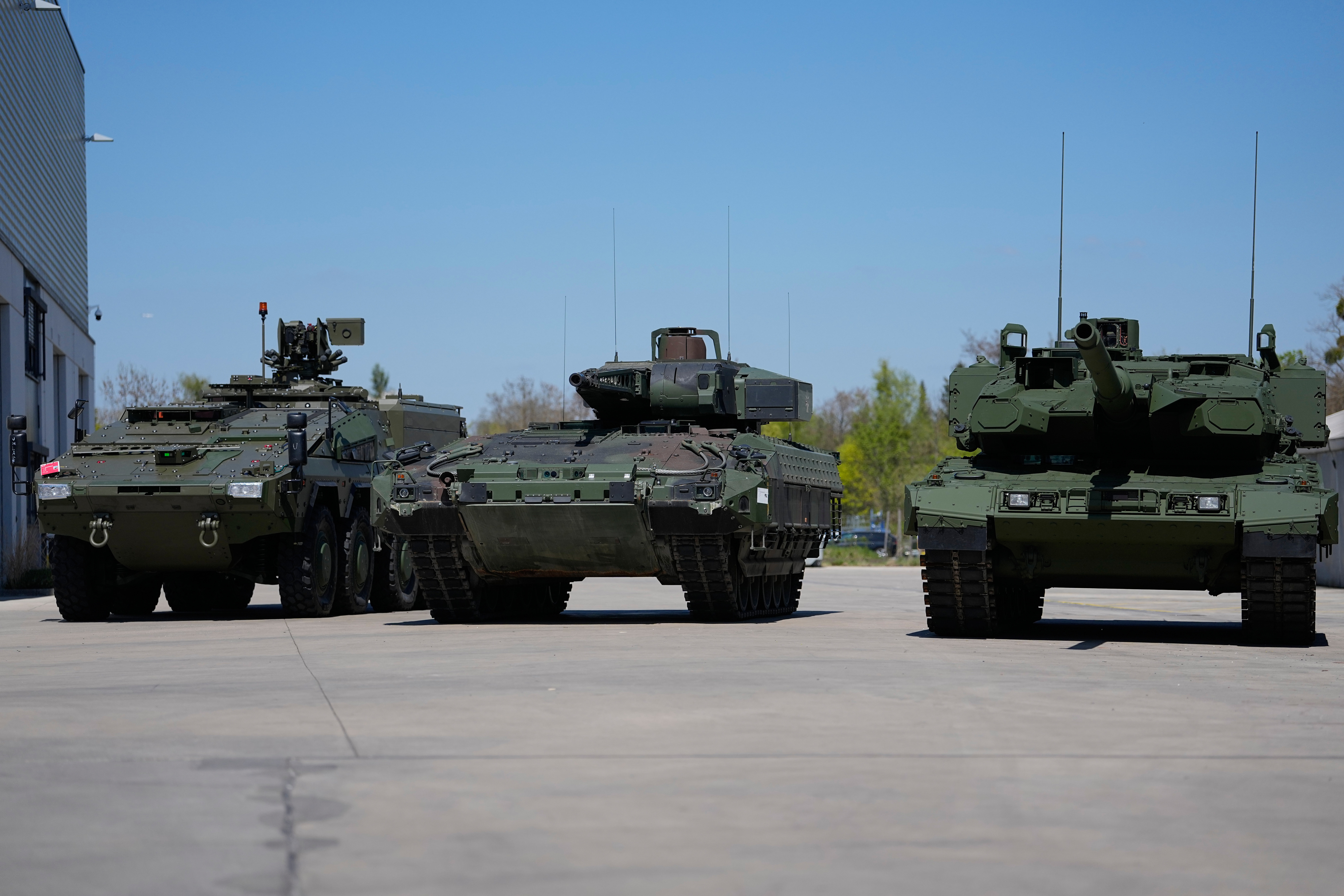 A boxer armoured personnel carrier, from left, a Puma infantry fighting vehicle and a Leopard battle tank are displayed during the opening of a new production line production line of Boxer 8x8 wheeled armoured personnel carrier produced by pan-European defense company KNDS in Munich, Germany, on April 22, 2026.