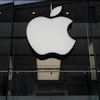 The Apple logo is illuminated at a store in Munich, April 2, 2026.