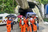 Members of the rescue team carry oxygen cylinders outside the entrance to an under-construction tunnel at a hydropower project in Samardung village, about 40 kilometers (25 miles) from Gangtok, India, Tuesday, July 21, 2026.
