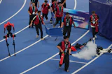 Officials extinguish a fire of a Humanoid robot after hitting the barrier at the end of the 100 meter final race during the World Humanoid Robot Games in Beijing, Wednesday, Aug. 26, 2026.