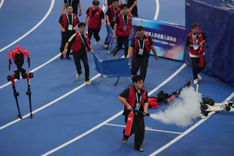 Officials extinguish a fire of a Humanoid robot after hitting the barrier at the end of the 100 meter final race during the World Humanoid Robot Games in Beijing, Wednesday, Aug. 26, 2026.
