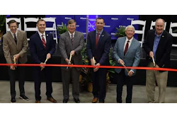 Six business professionals participate in a ribbon-cutting ceremony at a Sentry corporate event