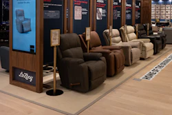 La-Z-Boy recliner showroom display with multiple brown and tan upholstered chairs under pendant lighting