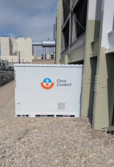 Clear Comfort HVAC unit with blue and orange logo at industrial facility with metal structures