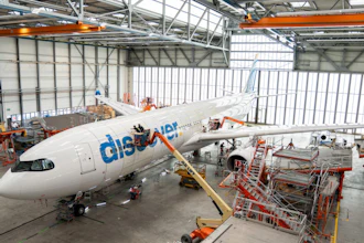 Flydubai aircraft undergoing maintenance in industrial hangar with orange support equipment and scaffolding