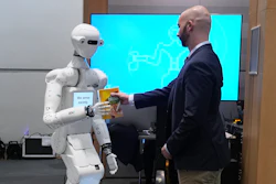 A man receives a box of chocolate powder drink from a robot during a demonstration of AI-based robotics in Europe at the European Parliament in Brussels, Wednesday, Sept. 2, 2026.
