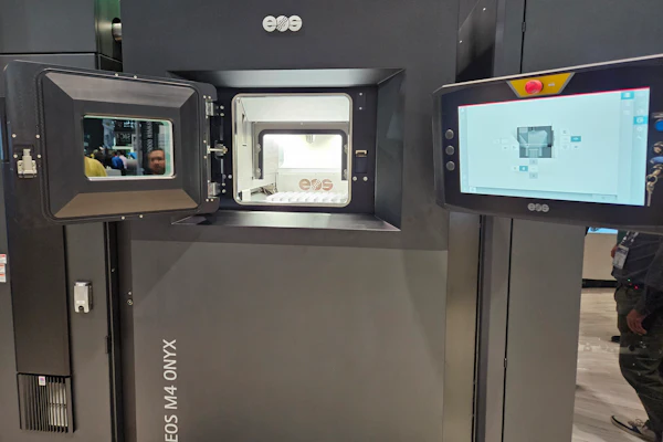 3D printer with open chamber displaying printing platform and control interface